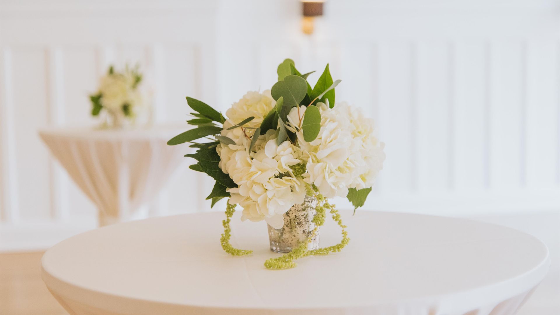 A White Plate Topped With A Vase Of Flowers On A Table