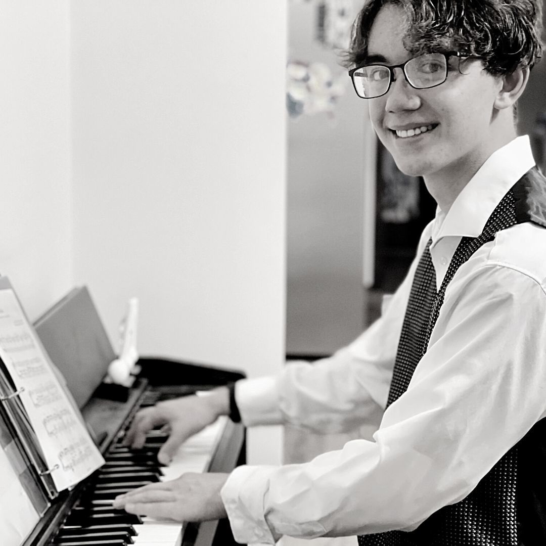 A Person Sitting At A Piano